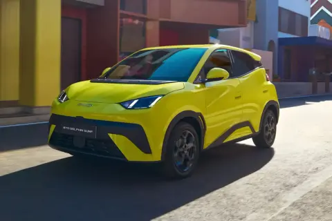 Żółty BYD Dolphin Surf jedzie ulicą.