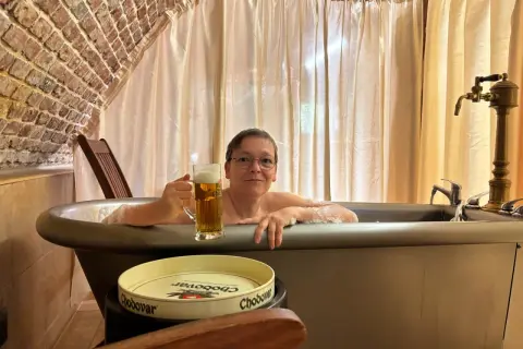 Entspannte Frau mit Bier im Bad des Chodovar Hotels.