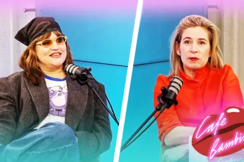 Eva Ekselius med bandana och solglasögon sitter vid en mikrofon. Bredvid henne sitter en kvinna i orange klänning.