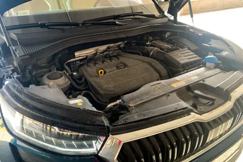Silnik Skoda Kodiaq, widok z góry, z otwartą maską. Widać elementy silnika, reflektor i grill.