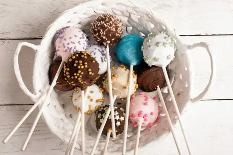 Kolorowe cake pops w białym koszyku. Idealne na imprezę, oto prosty cake pops przepis.