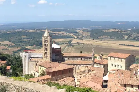 Panoramica di Massa Marittima: la cattedrale romanica con la sua torre svetta tra i tetti rossi, un invito a scoprire cosa vedere in questo borgo toscano.