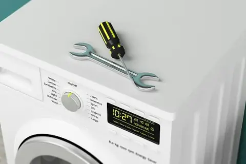 Outil de réparation sur un sèche-linge qui ne sèche plus. Le tournevis et la clé indiquent un problème.
