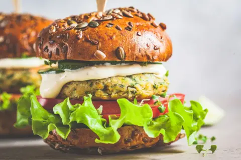 Pyszny wege burger z ziarnistą bułką, soczystą sałatą, pomidorem i kremowym sosem. Zastanawiasz się, ile kalorii ma wege burger?