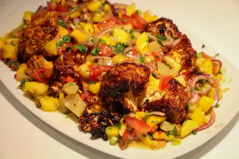 Ugnsbakad blomkål med en fräsch mangosalsa. Ett perfekt recept för en somrig middag.