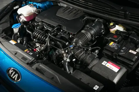 Detalle de los motores Kia, con el logo de la marca en azul brillante y componentes del motor turbo.