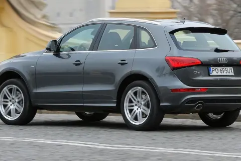 Szary Audi Q5 8R w ruchu miejskim, z widocznym tyłem i bokiem pojazdu.