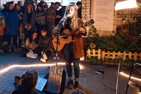 Alice Phoebe Lou spielt in Berlin vor begeistertem Publikum. Eine Lichterkette umrahmt die Bühne.
