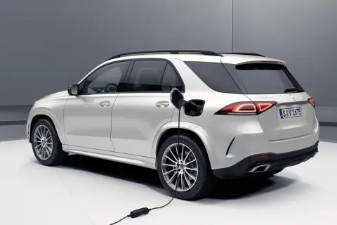 Biały SUV Mercedes-Benz jest ładowany. Zastanawiasz się, czy warto kupić hybrydę? Ten model pokazuje przyszłość motoryzacji.