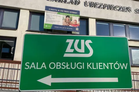 Zielony znak z logo ZUS i napisem "SALA OBSŁUGI KLIENTÓW" wskazuje drogę do placówki zarządzania socjalnego ubezpieczenia.