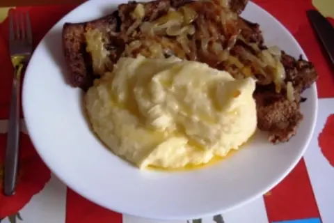 Herzhaft gebratene Leber mit Zwiebeln und cremigem Kartoffelbrei auf einem Teller. Ein Klassiker, der Appetit macht.
