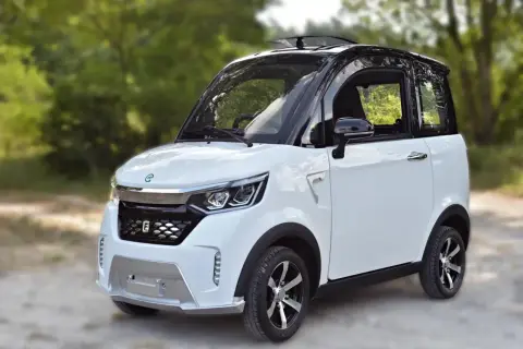Piccola macchina bianca e nera, perfetta per chi cerca una soluzione di mobilità urbana senza patente.