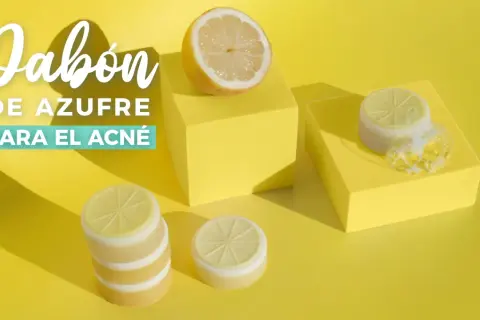 Jabón de azufre para el acné, con limones y burbujas sobre cubos amarillos.