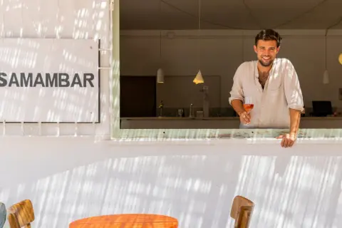 Hombre sonriente con copa de vino rosado en Samamabar, un lugar ideal para comer en Rodalquilar.