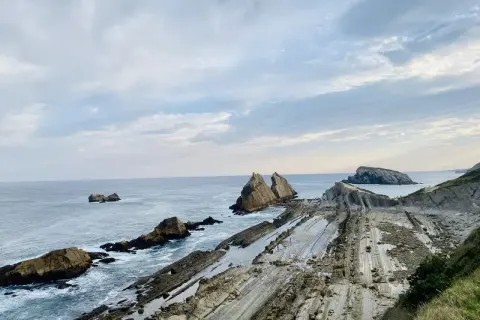Acantilados de Liencres con formaciones rocosas únicas y el mar Cantábrico.