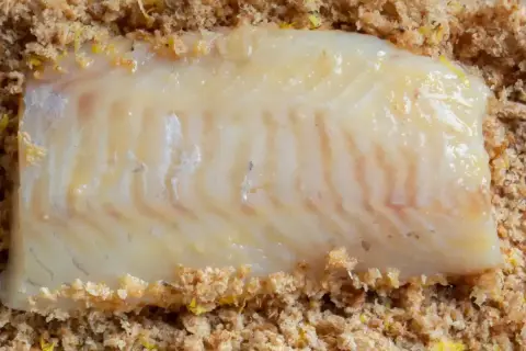 Filet ryby w panierce panko, gotowy do smażenia. Panko to japońska bułka tarta, która nadaje potrawom chrupkość.