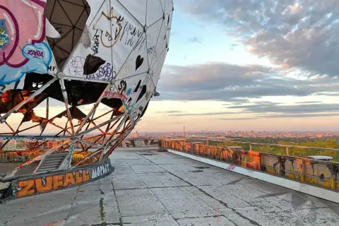 Graffiti-bedeckte Kuppel des Teufelsberg Berlin mit Blick auf die Stadt bei Sonnenuntergang.