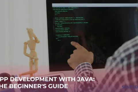 Un homme suit un tutoriel Java sur son écran, avec un mannequin en bois à côté.