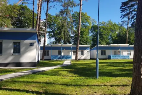 Urocze domki letniskowe w Międzyzdrojach, otoczone zielenią, zapraszają na wypoczynek. Numer 21 widoczny na jednym z budynków.