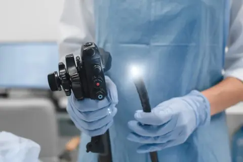 Lekarz w rękawiczkach trzyma endoskop. To narzędzie, które pomaga najlepszym onkologom od raka jelita grubego w diagnostyce.