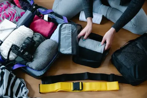 Pakowanie walizki na wakacje: ubrania, aparat, notatnik i akcesoria.