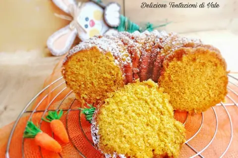 Torta di carote Bimby soffice e profumata, decorata con zucchero a velo e carotine decorative.