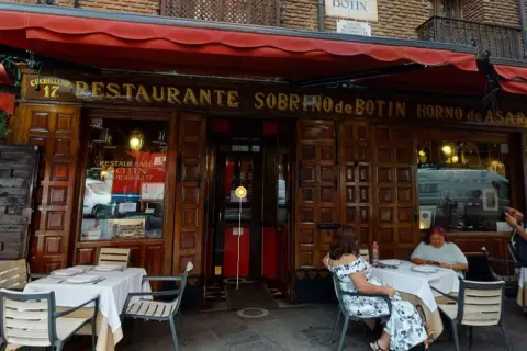Fachada del restaurante Sobrino de Botín, el restaurante más antiguo de España, con mesas puestas en el exterior.