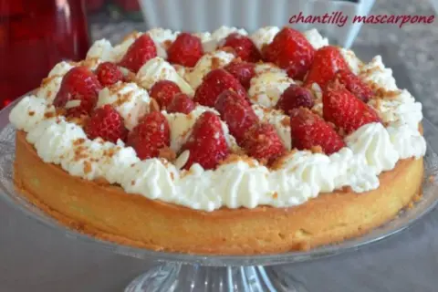 Délicieuse tarte aux fraises chantilly, garnie de fruits rouges frais et de crème onctueuse, saupoudrée de miettes croustillantes.