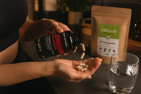 Frau nimmt Ashwagandha-Kapseln ein. Wann einnehmen? Am besten morgens oder abends für Stressabbau und Wohlbefinden.
