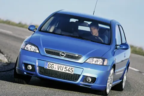 Niebieski Opel Astra G CC z kierowcą na drodze.