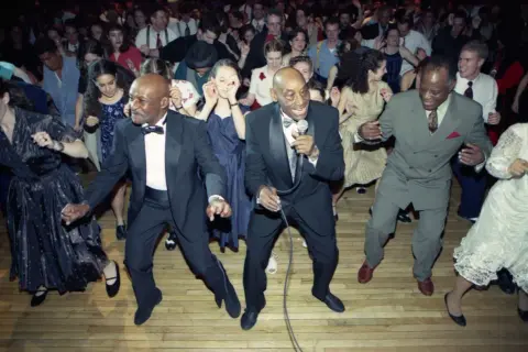 Ballerini in abiti eleganti si scatenano al ritmo della musica swing.