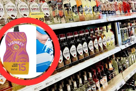 Wódka na półce sklepowej, obok kolorowy likier Monkey Mango.