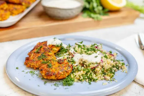Halloumi och morotsbiffar serveras med en fräsch bulgursallad och en klick yoghurt. En härlig vegetarisk rätt!