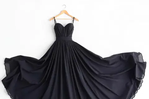 Elegancka, czarna sukienka na ramiączkach z lejących się tkanin na sukienki, rozwiana na boki.