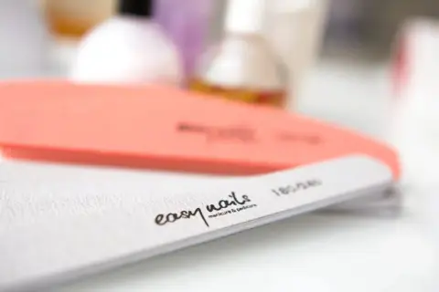 Pilniki do paznokci, jeden pomarańczowy, drugi biały z napisem "easy nails manicure & pedicure". Idealne do wykonania japońskiego pedicure.
