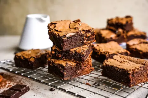 Gestapelte, saftige Brownies auf einem Gitter, bereit zum Genießen. Dieses Brownie-Rezept ist ein Traum für jeden Schokoladenliebhaber.