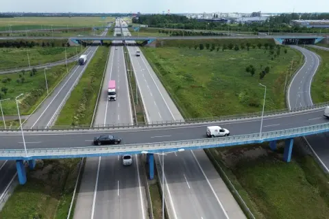 Widok z lotu ptaka na wielopoziomowy węzeł autostradowy z ruchem samochodowym i ciężarowym.