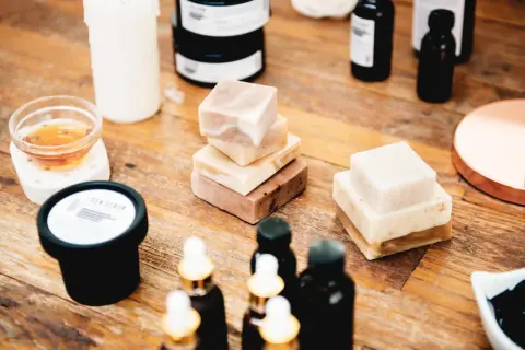 Naturalne kosmetyki: kostki mydła, olejki w buteleczkach, świeca i słoiczek z napisem "SEA SCRUB". W składzie niektórych produktów może znajdować się metylu parahydroksybenzoesan.