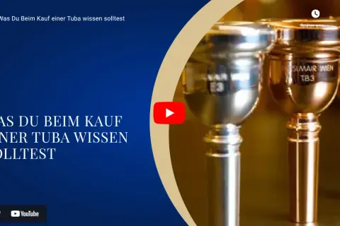 Nahaufnahme von Mundstücken eines Blechblasinstruments, einer Tuba. Der Text "Was Du Beim Kauf einer Tuba wissen solltest" ist sichtbar.