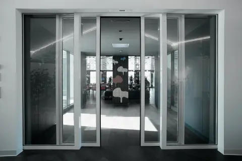 Modern interior with automatic, floor-to-ceiling ventanas correderas o abatibles, revealing a vibrant dining area with cloud-themed decor.