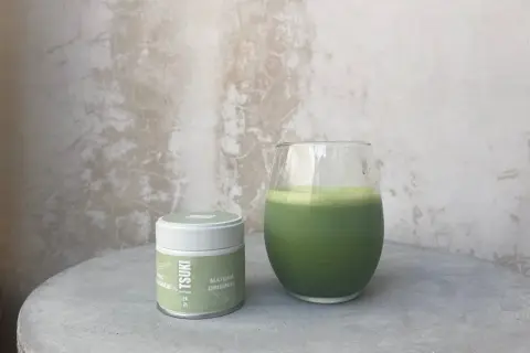 Boîte de matcha Tsuki et un verre de boisson verte. La quantité de matcha par tasse est parfaite pour un moment de détente.
