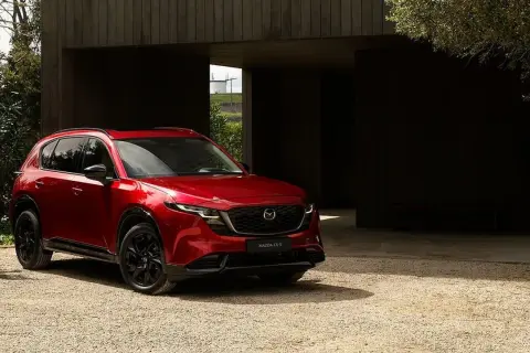 Czerwona Mazda CX-5 na żwirowym podjeździe. Sprawdź aktualną mazda cx-5 cena i wybierz swój wymarzony SUV.