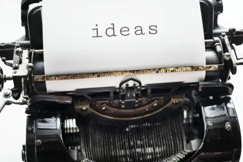Stara maszyna do pisania z napisem "ideas" na papierze. Czasem potrzebujemy nowych pomysłów, by odpowiedzieć na trudne pytania o życiu.