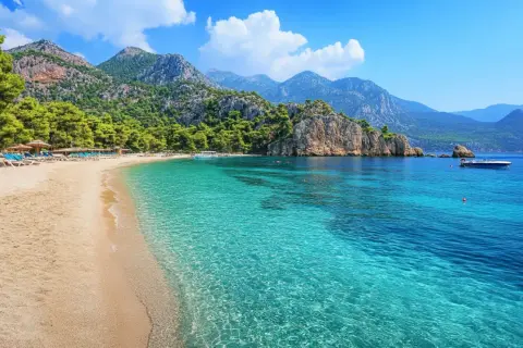 Piękna plaża z turkusową wodą i górami w tle. Idealne miejsce na wakacje, zastanawiasz się, ile się leci do Turcji?