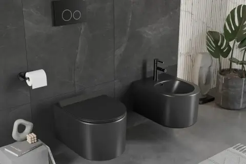 Nowoczesny wc kompakt w matowej czerni, obok bidet, na tle ciemnych płytek. Elegancka łazienka.