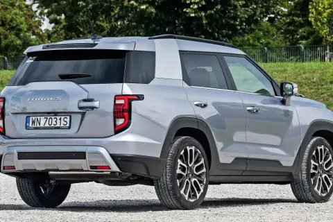 Srebrne auto Torres z polskimi tablicami WN 7031S zaparkowane na żwirowej drodze.