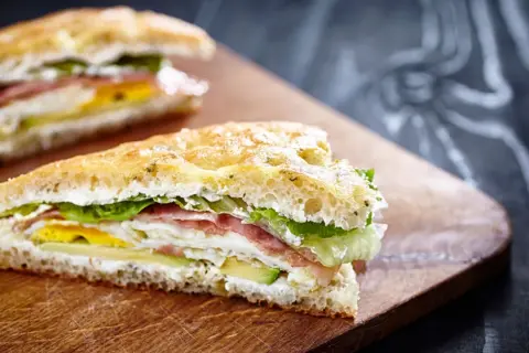 Tramezzini gourmet con prosciutto, uovo, avocado e lattuga su pane soffice. Un'idea per ricette veloci e gustose.