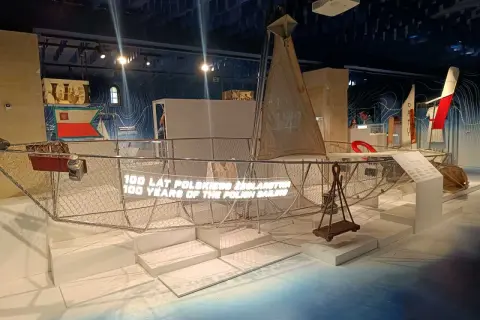 Wystawa w muzeum morskim Gdańsk dla dzieci: model żaglowca z napisem "100 lat polskiego żeglarstwa".