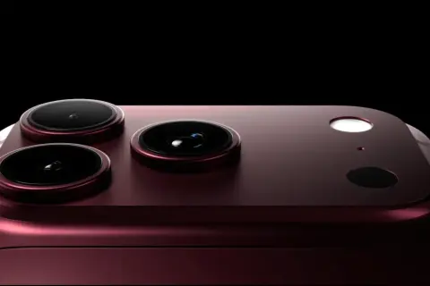 Ciemnoczerwony iPhone 18 Pro Max z trzema obiektywami aparatu i lampą błyskową na czarnym tle.