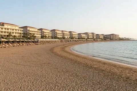 Piękna plaża z rzędami leżaków i białymi hotelami w tle, idealne miejsce na wakacje w Side Colakli.